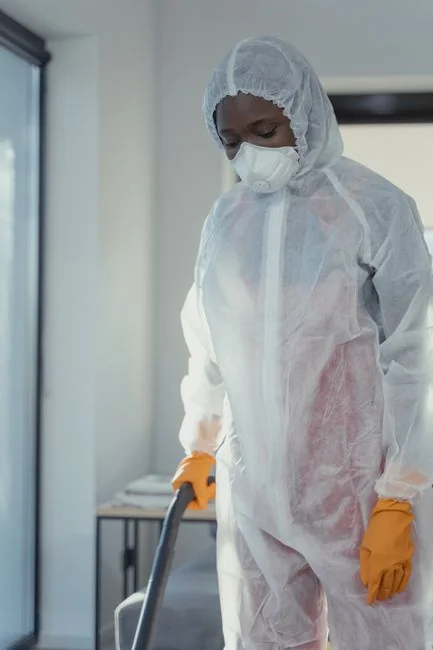 A cleaner is washing the floor in a laboratory setting